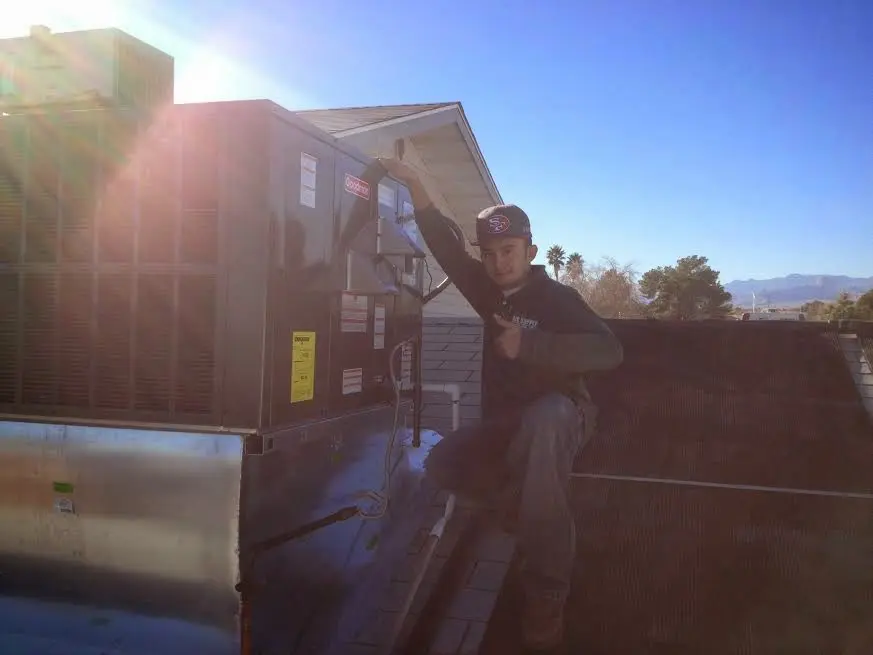 HVAC technician performing HVAC Inspection on a rooftop unit in Kent